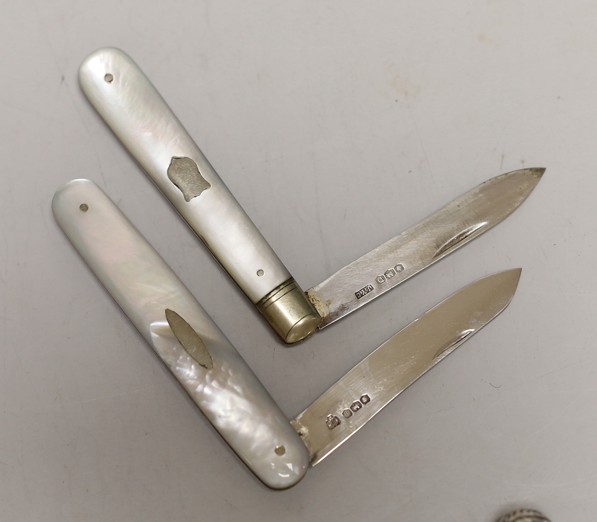 A late Victorian engraved silver vesta case, 53mm, two mother of pearl mounted silver fruit knives and a white metal dip pen.